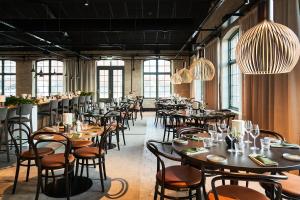 una sala da pranzo con tavoli, sedie e finestre di Quality Hotel Match a Jönköping