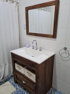 a bathroom with a sink and a mirror at Apart Esperanza in Esperanza
