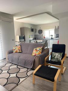 a living room with a couch and a chair at Timpa House Alle Pendici Dell'Etna in Paterno