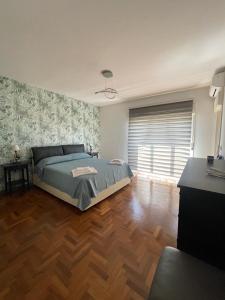 a bedroom with a bed and a wooden floor at Timpa House Alle Pendici Dell'Etna in Paterno