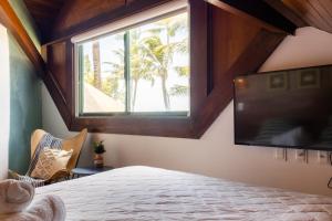 a bedroom with a bed and a large window at Bangalô beira-mar do Marulhos Resort em Muro Alto in Porto De Galinhas