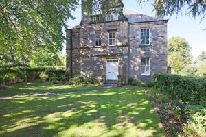 an old stone house with a grass yard at ALTIDO Lovely 4 bed house, private garden and free parking in Edinburgh
