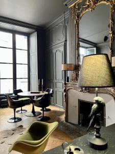 uma sala de estar com um espelho e uma mesa e cadeiras em Luxueux 2 pièces 65m2 Hôtel Particulier XVII ième siècle-Centre Historique Clermont-Ferrand em Clermont-Ferrand