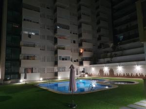 una piscina frente a un edificio por la noche en Sunny apartment Benidorm, en Cala de Finestrat