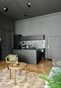 a living room with a table and a kitchen at Luxueux 2 pièces 65m2 Hôtel Particulier XVII ième siècle-Centre Historique Clermont-Ferrand in Clermont-Ferrand