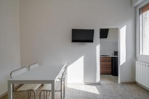 波隆那的住宿－Bella Bologna by Wonderful Italy，白色的用餐室配有桌子和墙上的电视
