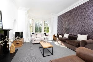a living room with a couch and a table at JOIVY Lovely 4 bed house, private garden and free parking in Edinburgh