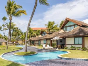 a resort with a swimming pool and palm trees at Bangalô beira-mar do Marulhos Resort em Muro Alto in Porto De Galinhas