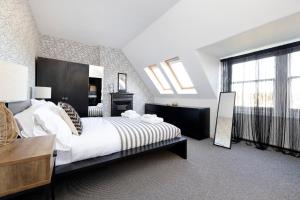 1 dormitorio con cama grande y ventana grande en ALTIDO Lovely 4 bed house, private garden and free parking, en Edimburgo