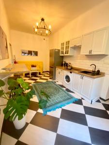 uma cozinha com piso em xadrez preto e branco em Topolove Rooms & Apartments em Cracóvia