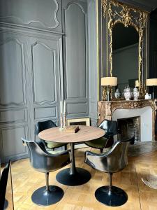 a table and chairs in a room with a fireplace at Luxueux 2 pièces 65m2 Hôtel Particulier XVII ième siècle-Centre Historique Clermont-Ferrand in Clermont-Ferrand