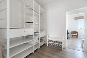 Casa Sol 21 A Garachico في غاراتشيكو: غرفة بيضاء مع رفوف بيضاء وطاولة