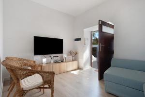 sala de estar con TV y sofá azul en Casa Sol 21 A Garachico, en Garachico