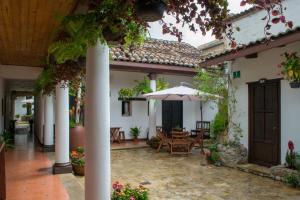 a courtyard of a house with a table and an umbrella at Arte Sano Hotel San Cristobal in San Cristóbal de Las Casas