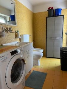 a bathroom with a washing machine and a toilet at Timpa House Alle Pendici Dell'Etna in Paterno