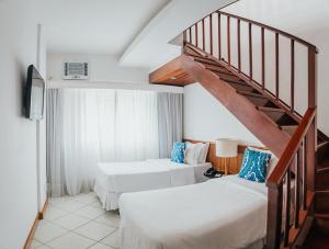 um quarto de hotel com duas camas e uma escada em Ipanema Inn Hotel no Rio de Janeiro
