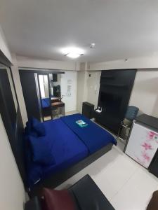 a bedroom with a blue bed and a tv at Toptravel Bassura City in Jakarta +26 photos