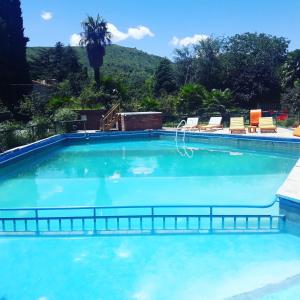 una gran piscina azul con sillas y árboles en Hosteria Pastoral & Spa en La Cumbre