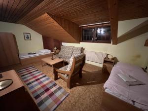 a living room with a bed and a couch at Apartmán Penziónu Hrubjak in Oravská Polhora