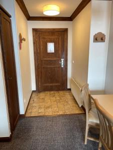 ブール・サン・モーリスにあるAppartement Arc 1950 - Manoir de Savoieの廊下(木製のドア、テーブル、椅子付) +1枚の写真