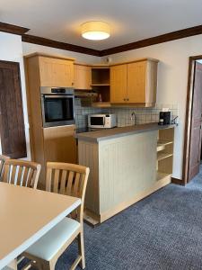 ブール・サン・モーリスにあるAppartement Arc 1950 - Manoir de Savoieのキッチン(木製キャビネット、テーブル、椅子付)