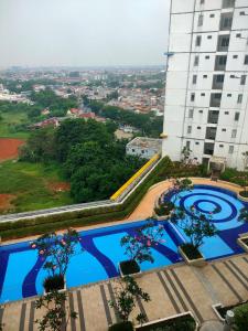 an overhead view of two swimming pools in front of a building at Toptravel Bassura City in Jakarta