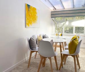 a dining room with a white table and chairs at Njordhame in Largs