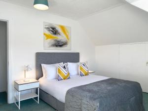 a bedroom with a bed and a table with a lamp at Njordhame in Largs
