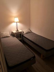 two beds in a room with a lamp on a table at Bjorli Apartment 203 (200m til Skitrekk) in Bjorli