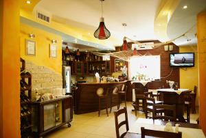 a restaurant with a bar and tables and chairs at Hotel Marina in Nielisz