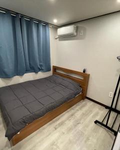 Cozy Sinchon 2548 في جيجو: غرفة نوم صغيرة بها سرير ونافذة