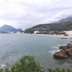 uma vista para uma praia com montanhas ao fundo em Acacia apartmani Sutomore em Sutomore