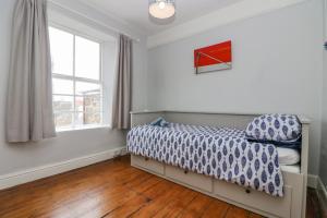 a bedroom with a bed and a window at Mackerel Sky in Penzance