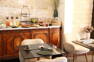 Avalon Cosy Hotel Paris في باريس: غرفة طعام مع طاولة وكراسي
