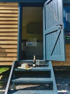 an open door with a bottle of wine and a glass at Roosters Retreat in Launceston