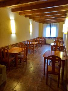 comedor con mesas y sillas de madera en Hostal Cabrerès, en Cantonigros