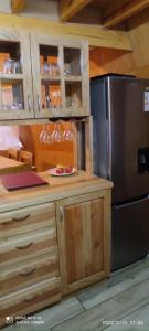a kitchen with a stainless steel refrigerator and wooden cabinets at Cabaña y Domo Rinconada de Malalcahuello in Malalcahuello