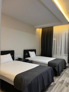 um quarto de hotel com duas camas e uma janela em ATLIHAN PLUS HOTEL em Doğubayazıt