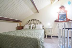 1 dormitorio con 1 cama con colcha verde en Case Vacanze Borgo Marina IMPERIA en Imperia