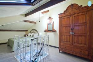 a bedroom with a large wooden cabinet and a bed at Case Vacanze Borgo Marina IMPERIA in Imperia