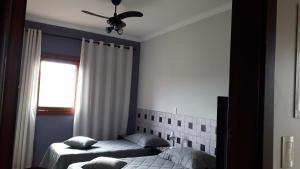 1 dormitorio con 2 camas y ventana en Um paraiso em meio à cidade en Campinas