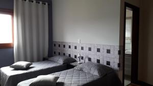 a bedroom with two beds and a mirror at Um paraiso em meio à cidade in Campinas