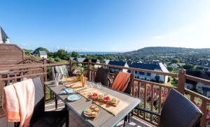 una mesa en un balcón con vistas a la ciudad en Pierre & Vacances Premium Residence & Spa Houlgate, en Houlgate
