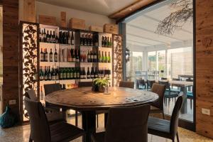 Pove del Grappa的住宿－HOTEL MIRAMONTI ENOTECA，一间用餐室,配有一张桌子和一堵葡萄酒瓶