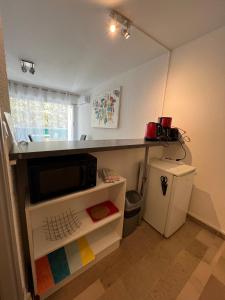 eine Küche mit einer Theke, einer Mikrowelle und einem Kühlschrank in der Unterkunft Studio Aphyllante, Carnon plage, 3 étoiles in Carnon-Plage