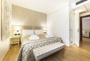 Pove del Grappa的住宿－HOTEL MIRAMONTI ENOTECA，一间卧室配有一张床,其中配有长凳