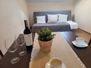 a table with a bottle of wine and two wine glasses at Pokoje i apartamenty "U Beaty" in Karwia