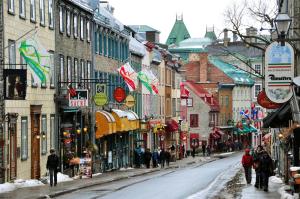 a city street with people walking down a snow covered street at Le Haute Ville in Quebec City