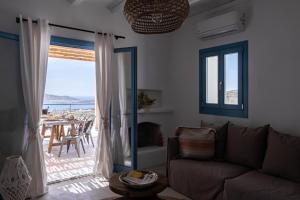 a living room with a couch and a view of the ocean at Serenity Villa w/ Pool in Butterfly Valley in Kampos Paros
