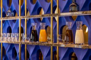 a row of wine glasses and wine bottles on a shelf at Hotel Le Rocroy in Paris